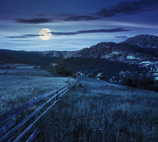 istock fence on hillside meadow in mountain at night 478912076