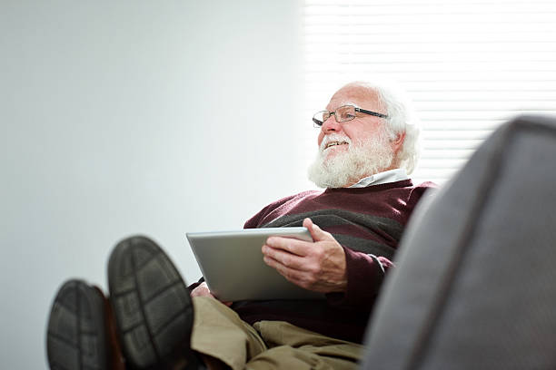 istock Happy senior man on sofa with a digital tablet 478915794