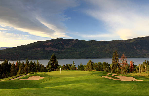 Watering of golf course with pond in foreground.