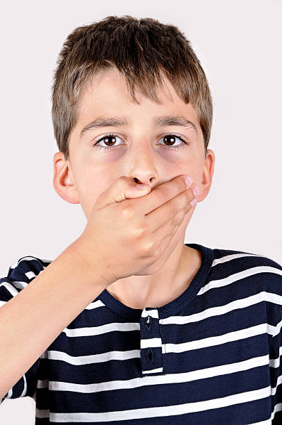 istock Young boy covering his mouth 478929120