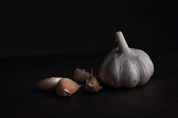 istock Garlic cloves on the black table. Black background 478931766