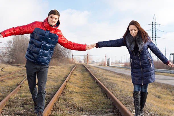 istock Playful couple balancing on the railway tracks 478932409