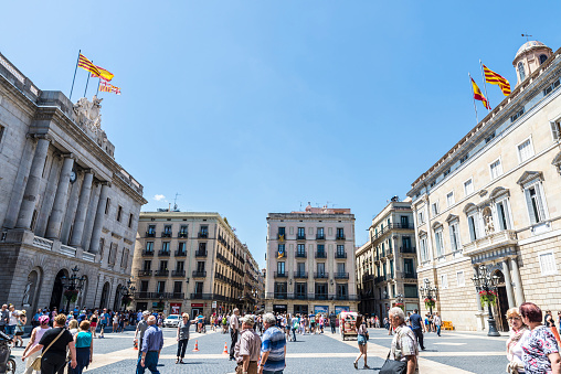 Barcelona,Spain - June 17, 2015: People walking in Sant Jaume square, in front of the facade of Barcelona city hall and Generalitat of Catalonia. This palace is the head office of the Presidency of the catalan government .