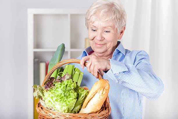 高齢者の女性のショッピングバスケット - vegies vegetable basket residential structure ストックフォトと画像