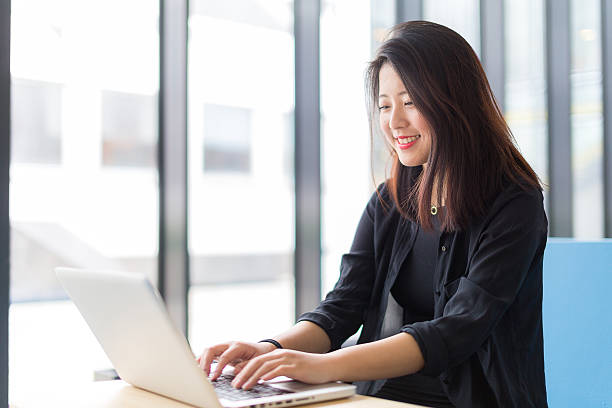 Asian college student sitting with a laptop