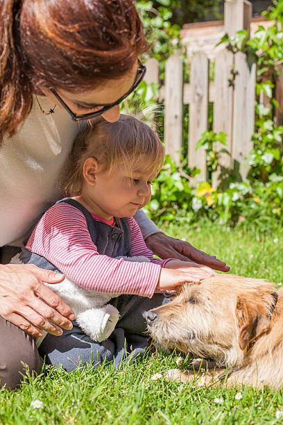 istock mother and baby petting dog 478949134
