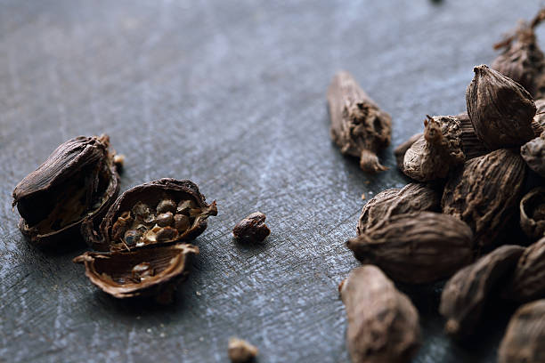 sementes de cardamomo preta sobre a mesa de madeira escura - cardamom spice macro asian culture imagens e fotografias de stock