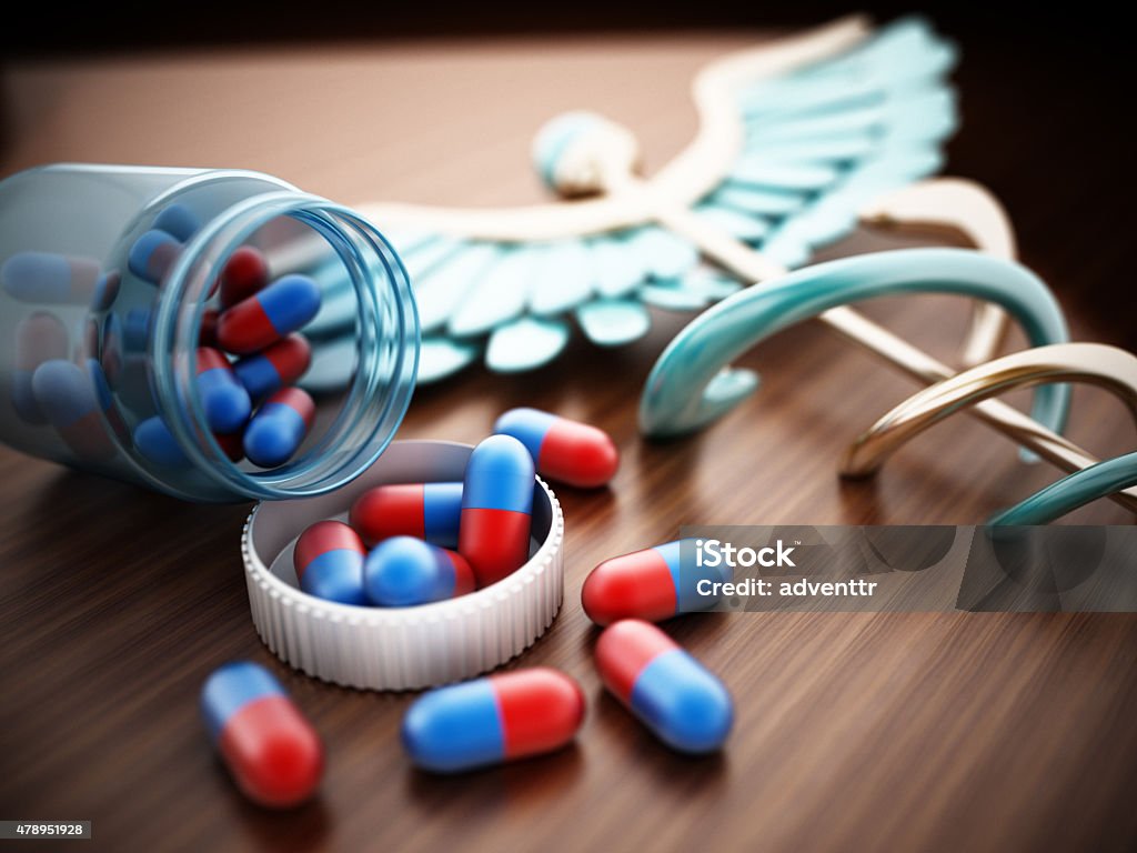 Pills on wooden table Blue and red pills that spilled out of the glas bottle standing on wooden table. 2015 Stock Photo