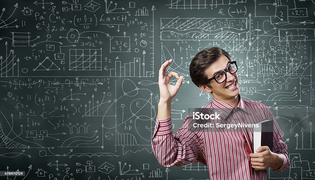 Funny botanist Young funny man in glasses against chalkboard with sketches Mathematician Stock Photo