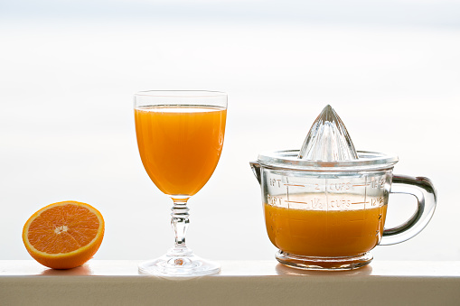 Fresh squeezed Orange juice in retro-stile hand squeezer Fresh squeezed Orange juice on city background
