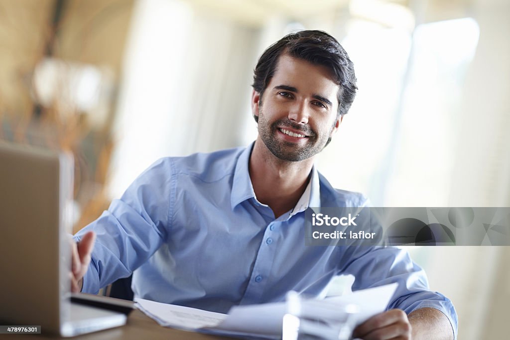 He's a financial whizz! A handsome young businessman working on his laptop at his desk 20-24 Years Stock Photo