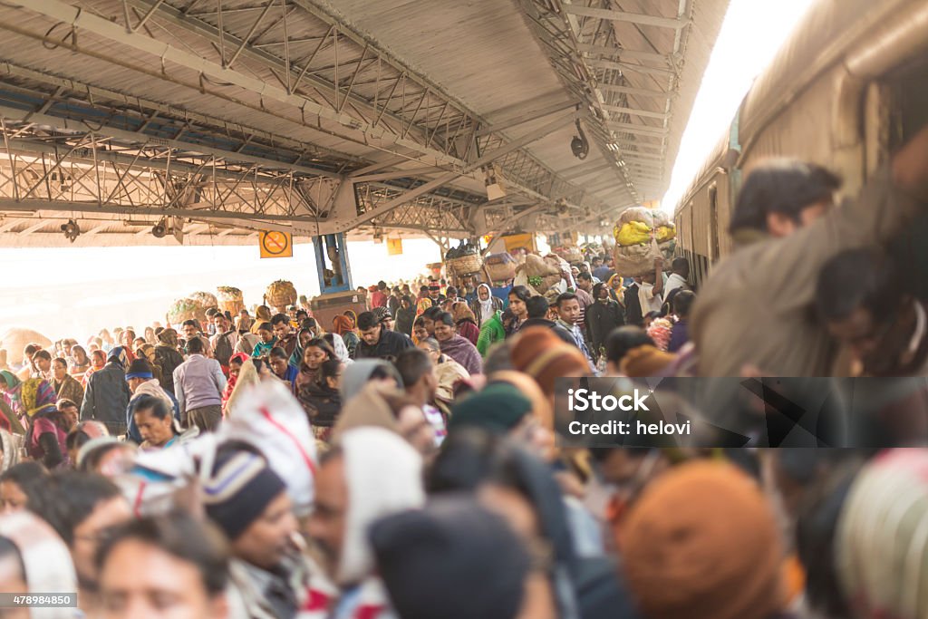 Train station in Kolkata Main train station in Calcutta is crowded all day and night. India. Large group of people walking at the railway station and traing to get on already crowded train. India Stock Photo