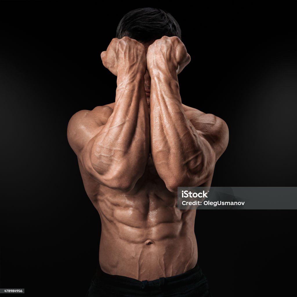 Power Hands in Front of Face Two Power Hands in Front of Face. Close-up of a man's fists and abs. Strong man's arm with muscles and veins. 2015 Stock Photo