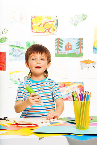 istock Boy with glue stick and pencils 478985129