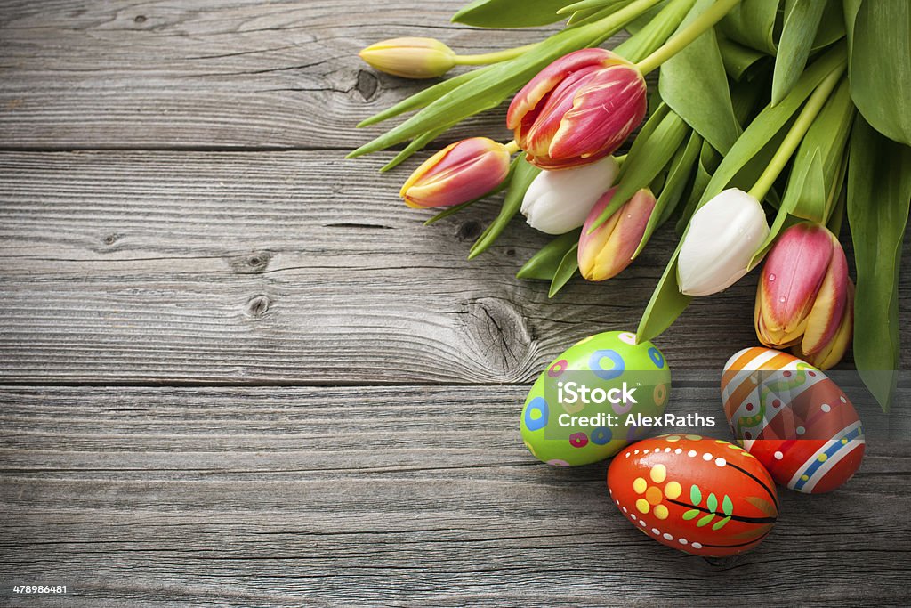 Easter eggs with tulips Easter eggs with tulips on weathered wooden background Animal Egg Stock Photo