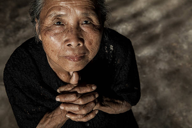 istock Elderly woman praying 478988384