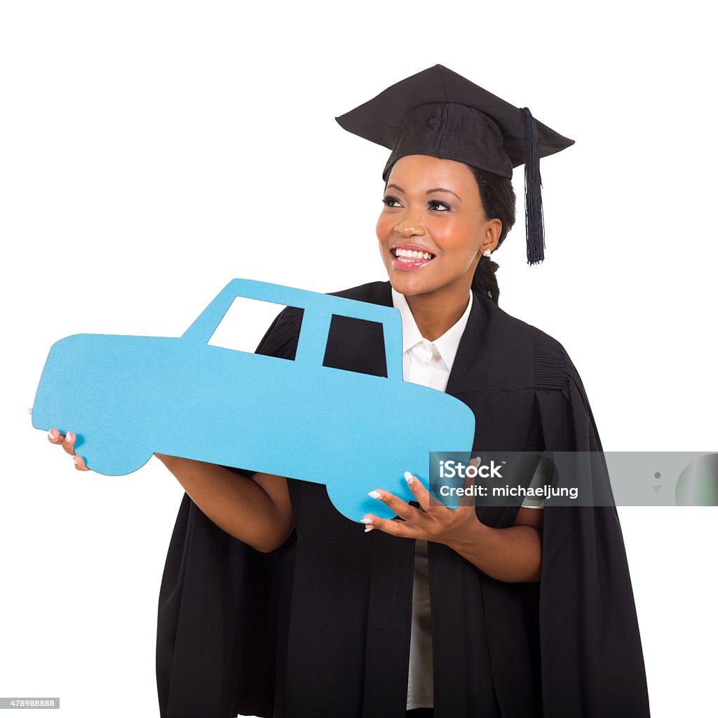 african american female graduate holding a car symbol gorgeous african american female graduate holding a car symbol on white background Graduation Stock Photo