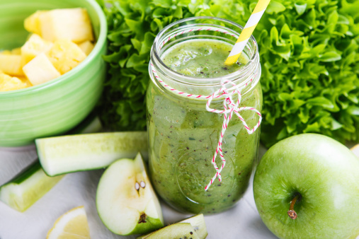 Fresh organic green smoothie with salad, apple, cucumber, pineapple and lemon as healthy drink