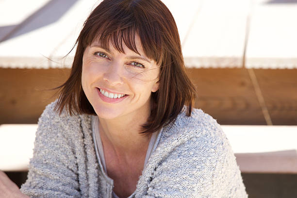 sains âgés de femme souriante à l'extérieur - cheveux mi longs photos et images de collection