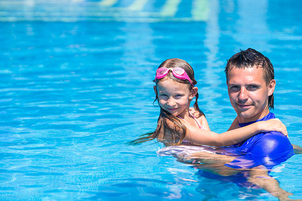 istock Young father and cute daughter playing in swimming pool 478995842