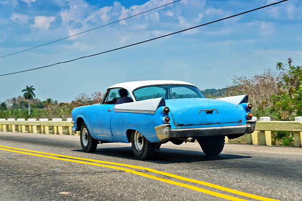 istock blue vintage car driving along the road 478995870