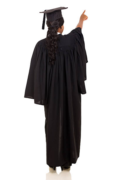 rear view of female graduate pointing isolated on white background