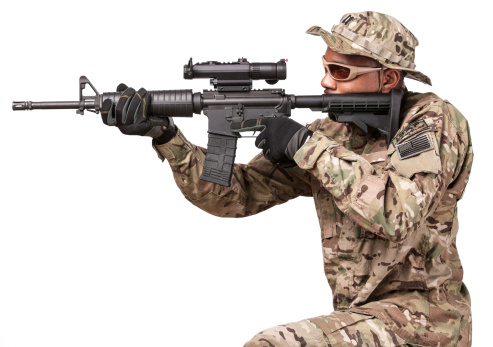An african american U.S. military soldier in modern uniform aims a scoped rifle at an unseen target to the left. Isolated on a pure white background.