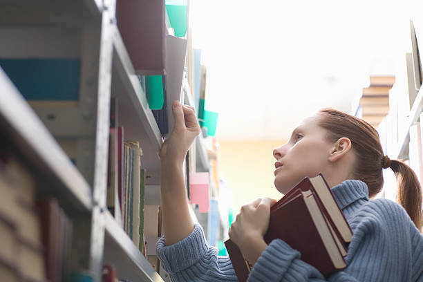 istock Woman Selecting Books From Bookshelf 478999171