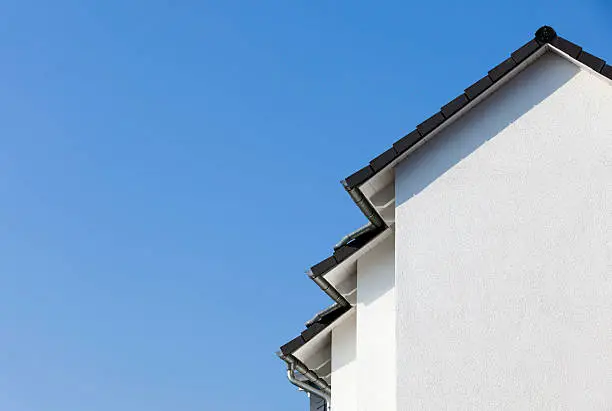 generic view to facade of a new house with blue sky in background