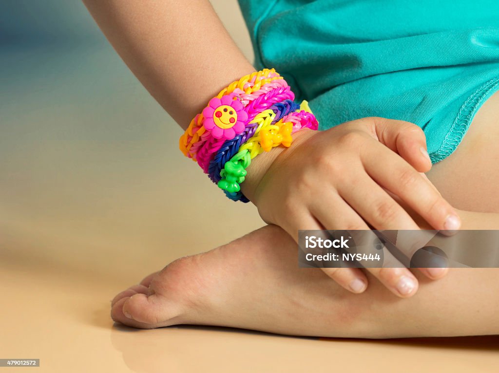 Loom bracelets on child hand close up.Rubber colorful wrist accessories. 2015 Stock Photo