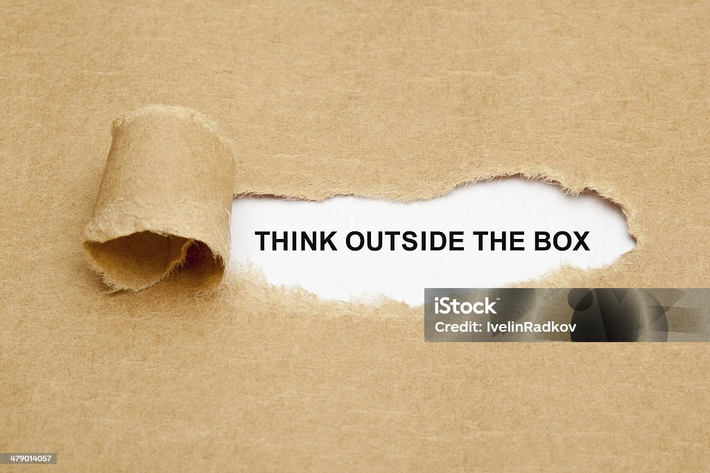 Think Outside The Box Torn Paper Think Outside The Box appearing behind torn brown paper. Breaking New Ground Stock Photo