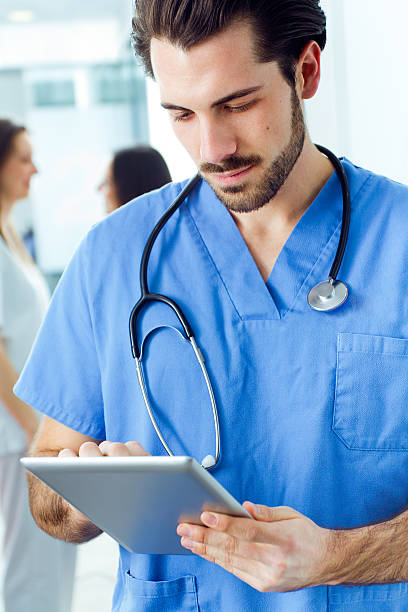 istock Cheerful young doctor looking at his digital tablet 479025221