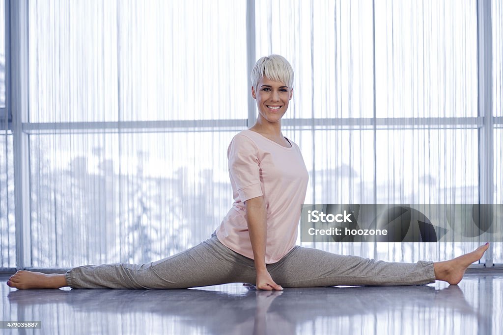 Young blond woman doing the splits. Active Lifestyle Stock Photo