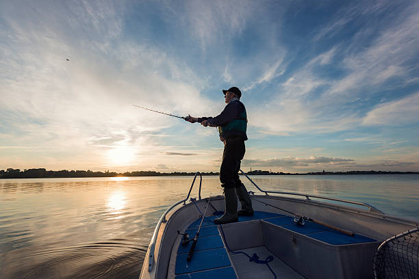 pescador moldagem fora sua linha - veículo aquático imagens e fotografias de stock