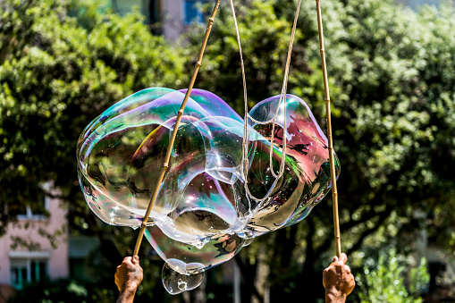 Big bubbles being blown in a park in Barcelona.