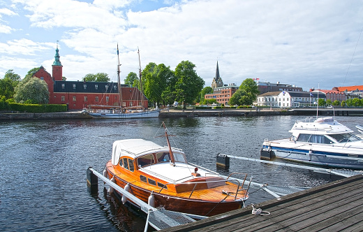 Halmstad, Sweden - June 7, 2015: Small motorboats moored along the quay by Nissan river with the medieval Danish style Halmstad castle behind.
