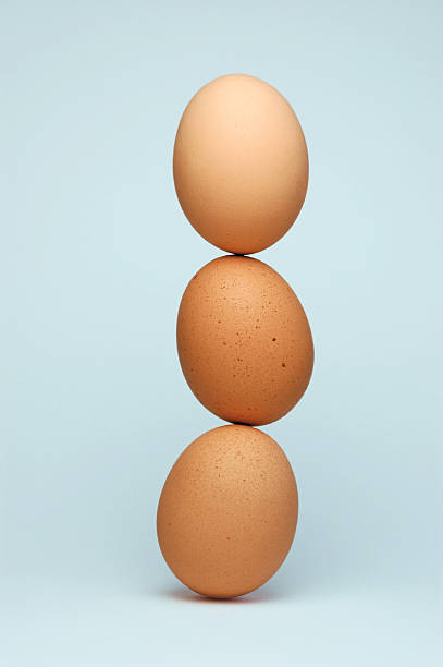 Three eggs balancing on top of each other stock photo