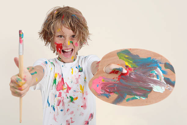 istock boy painting with brush and pallete 479054601