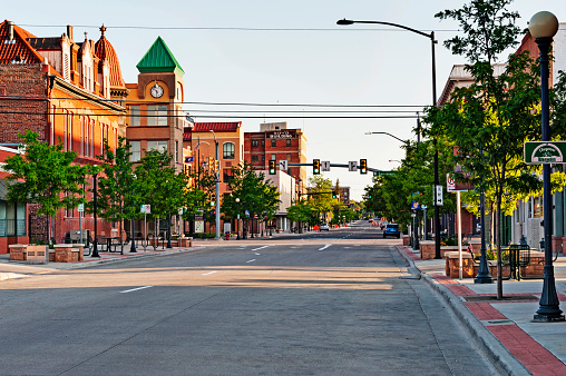 Cheyenne, Wyoming, USA - June 22, 2015: This view looking downtown on one of the main streets in Cheyenne takes in the Buisiness District with a variety of architectural styles and of various ages  and by looking down the street you see a tree lined view with signs and traffic lights, and all the appearance of a growning Capital City and on this June evening it  was very rewarding to see the various sights.