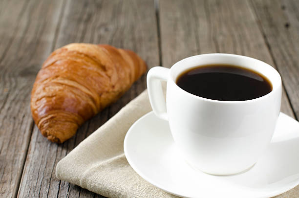 istock cup of coffee on a table with croissant 479061650