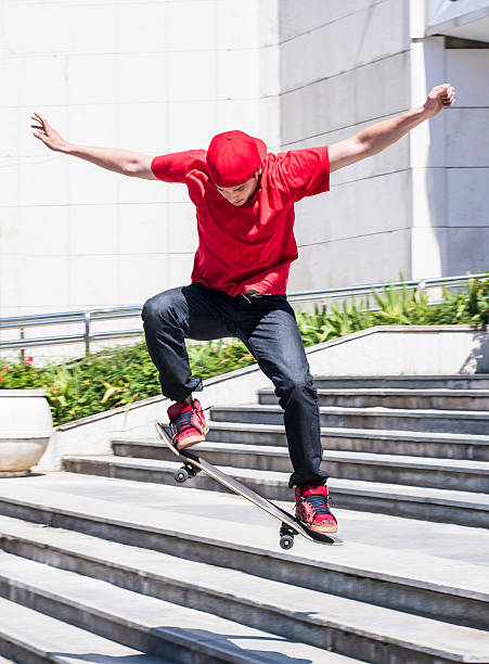 Skateboarder at skate park Skateboarder doing a skateboard trick, jumping from the stairs skater feet stock pictures, royalty-free photos & images