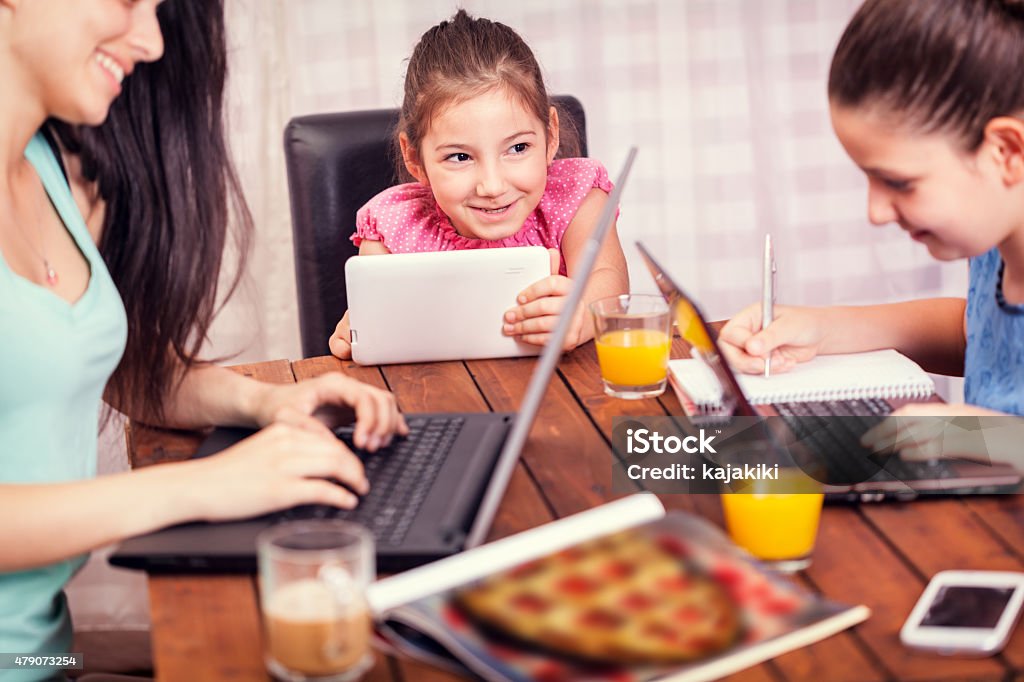 Familia joven usando una variedad de dispositivos digitales CNGLTEC168 - Foto de stock de 10-11 años libre de derechos