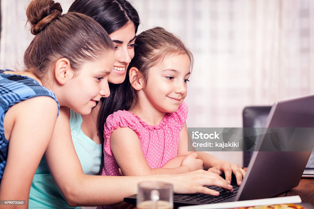 Feliz familia joven usando una computadora portátil - Foto de stock de 10-11 años libre de derechos