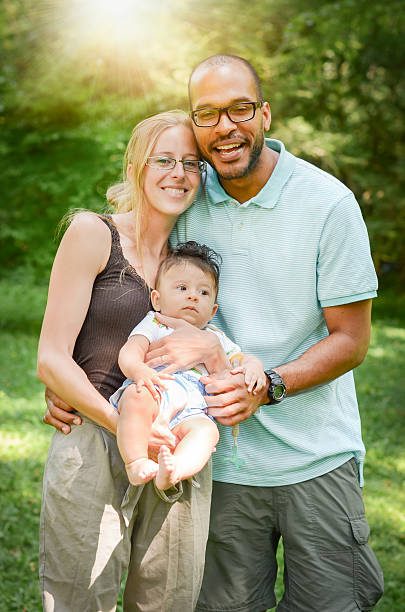 счастливый interracial семья, наслаждаясь день в парке - adoption family multi ethnic group human teeth стоковые фото и изображения