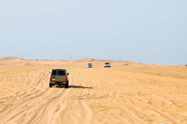 M'Hamid, Morocco - February 4, 2013: Off-road jeep standing on a horizon next to a big palm tree on sunny day near M'Hamid village near Sahara desert in Morocco