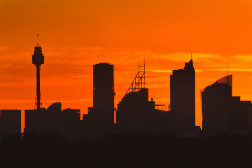 Australia Sydney city CBD silhouette distant view at sunset high contrast against bright orange sky - skyscrapers and towers