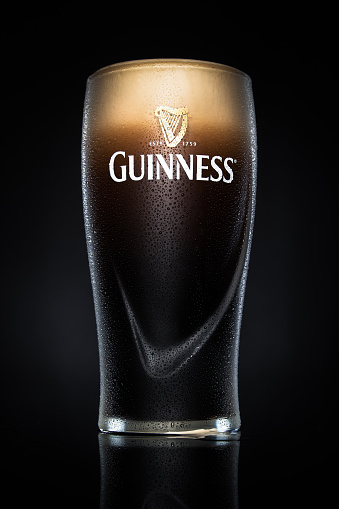 Eindhoven, The Netherlands - May 18, 2015: Pint of Guinness, the popular Irish beer on a black background. Guinness is one of the most successful beer brands worldwide.