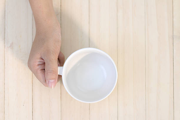 istock Woman hand holding empty white coffee cup.plank wood background. 479094562
