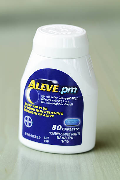 Aleve Pain Reliever and Sleep Aid Medicine West Palm Beach, USA - May 17, 2015: A container of Aleve PM pain reliever and night time sleep aid caplets. Aleve is a Bayer product and claims to provide 12 hours of pain relief.  bayer schering pharma ag photos stock pictures, royalty-free photos & images