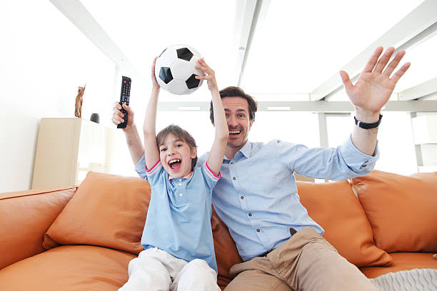 istock father and son wathcing football 479095278
